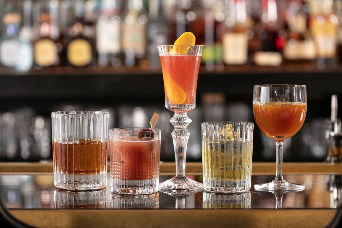 a lineup of cocktails on a bar
