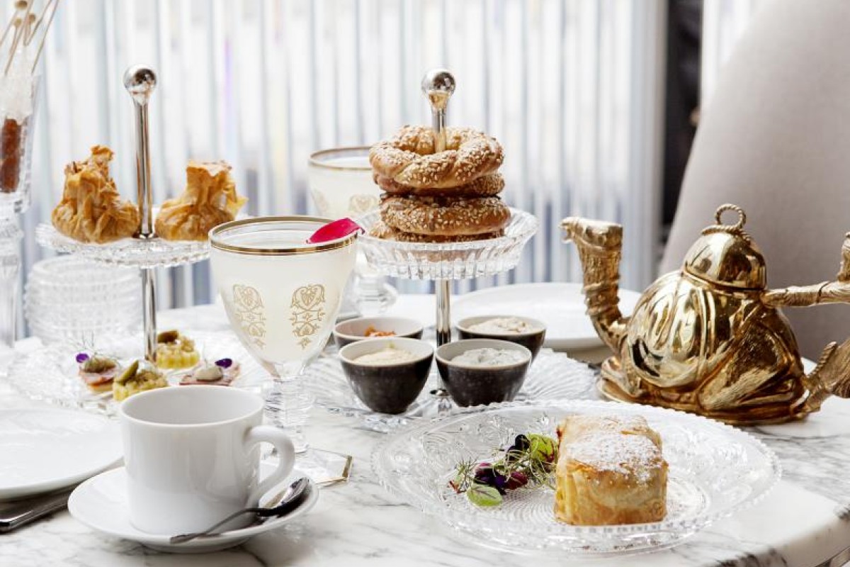 An afternoon tea station with tea, bagels, sweets, and coffee