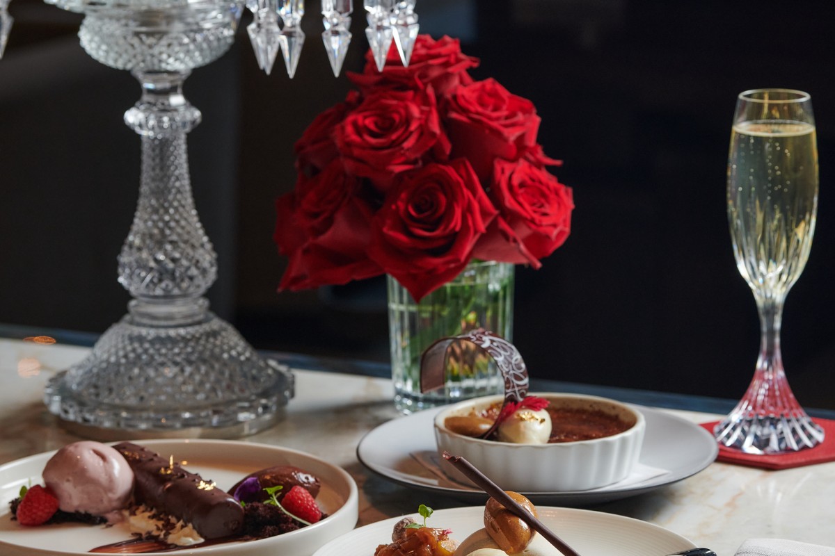 A beautifully set table featuring various plates and a glass of red wine