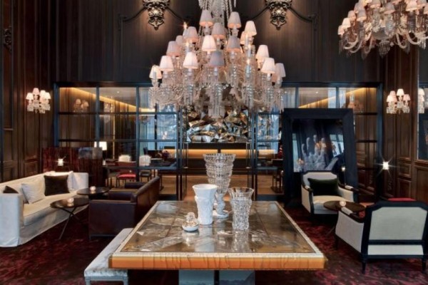 A table with a beautiful chandelier hanging above it int eh Lobby at Baccarat New York