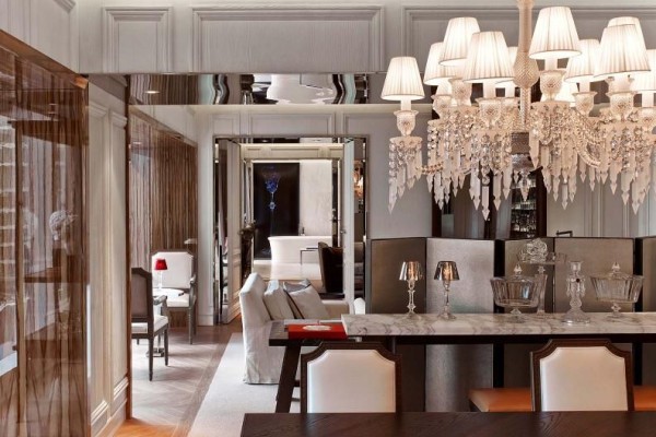 A room in Baccarat with a dining table, chandelier and a large living space