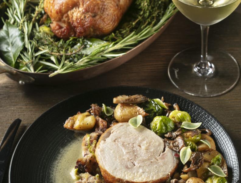 plate with carved turkey dinner and a glass of white wine