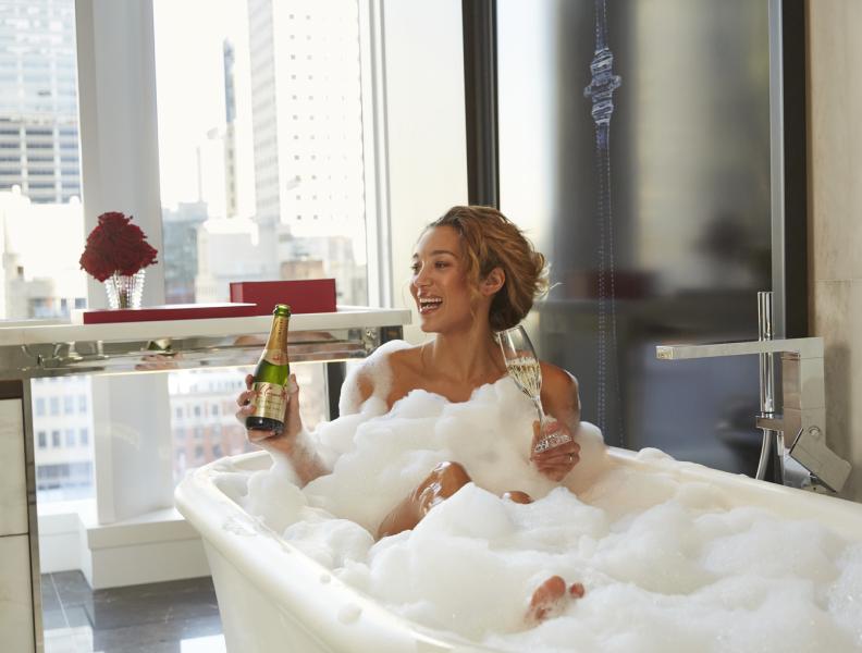 woman in bathtub drinking champagne