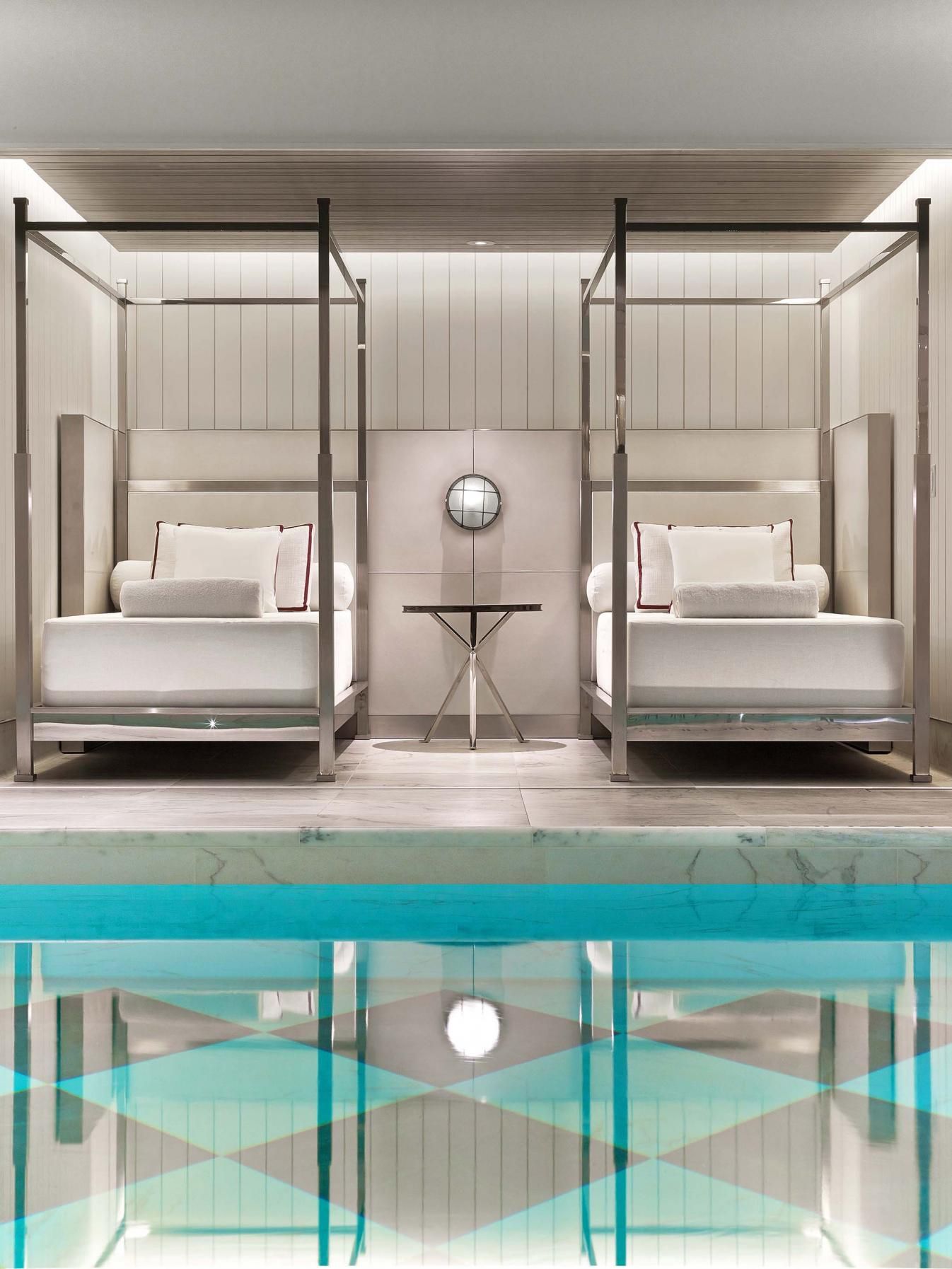 Two day beds by the side of an interior swimming pool