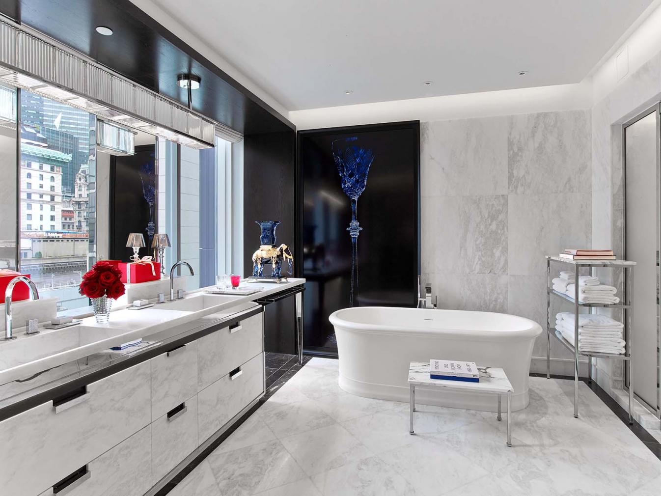 The bathroom of a Baccarat suite complete with two sinks, and a large bathrub