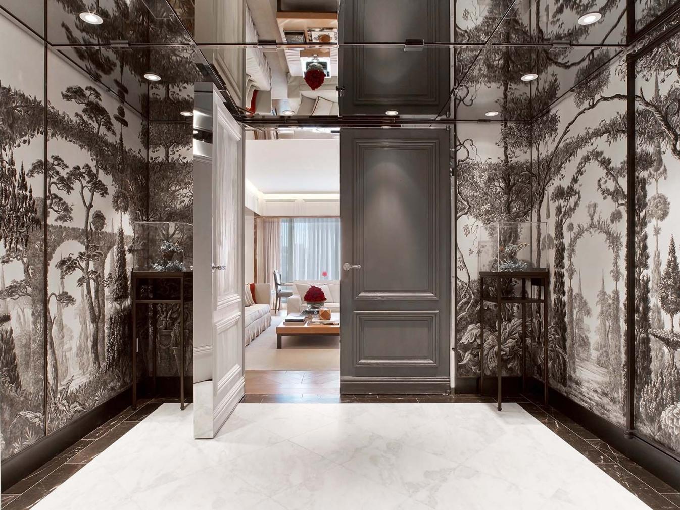 The open left side of a double gray door offers a peek inside of a Baccarat suite