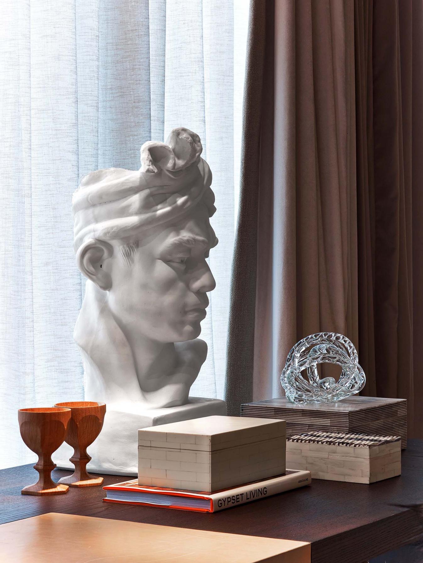 A well sculptured bust sits atop a table facing to the right
