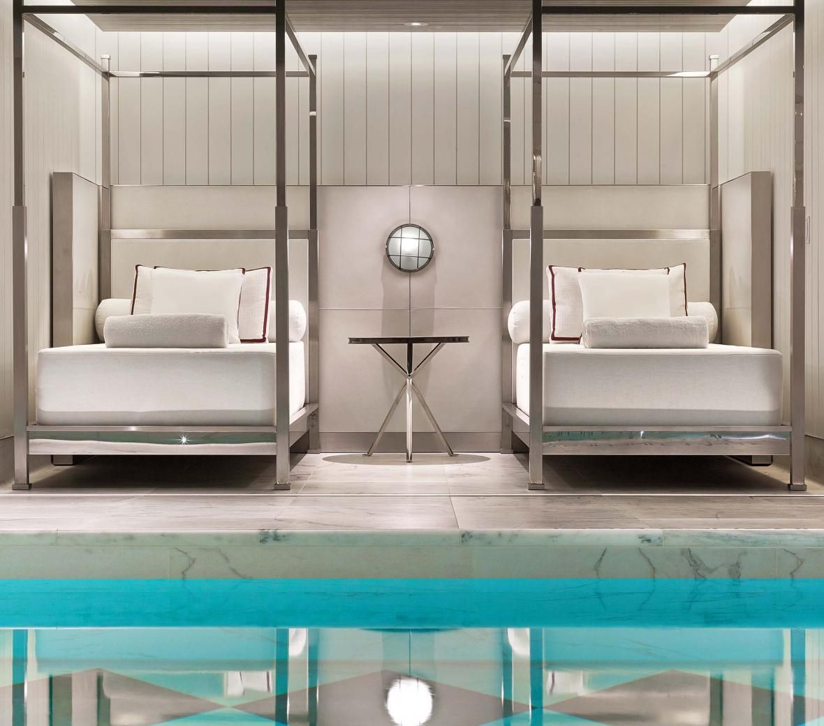 Two day beds by the side of an interior swimming pool