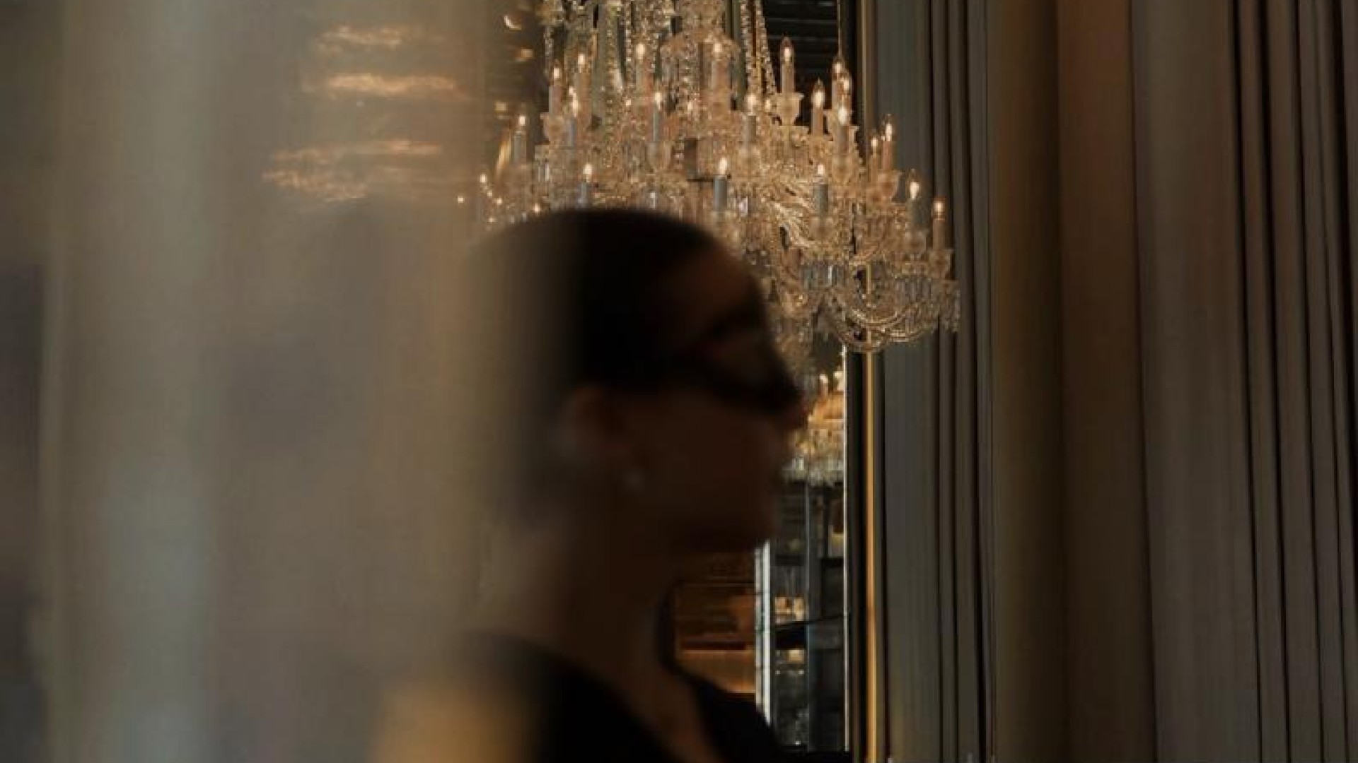 A woman standing in front of a chandelier 