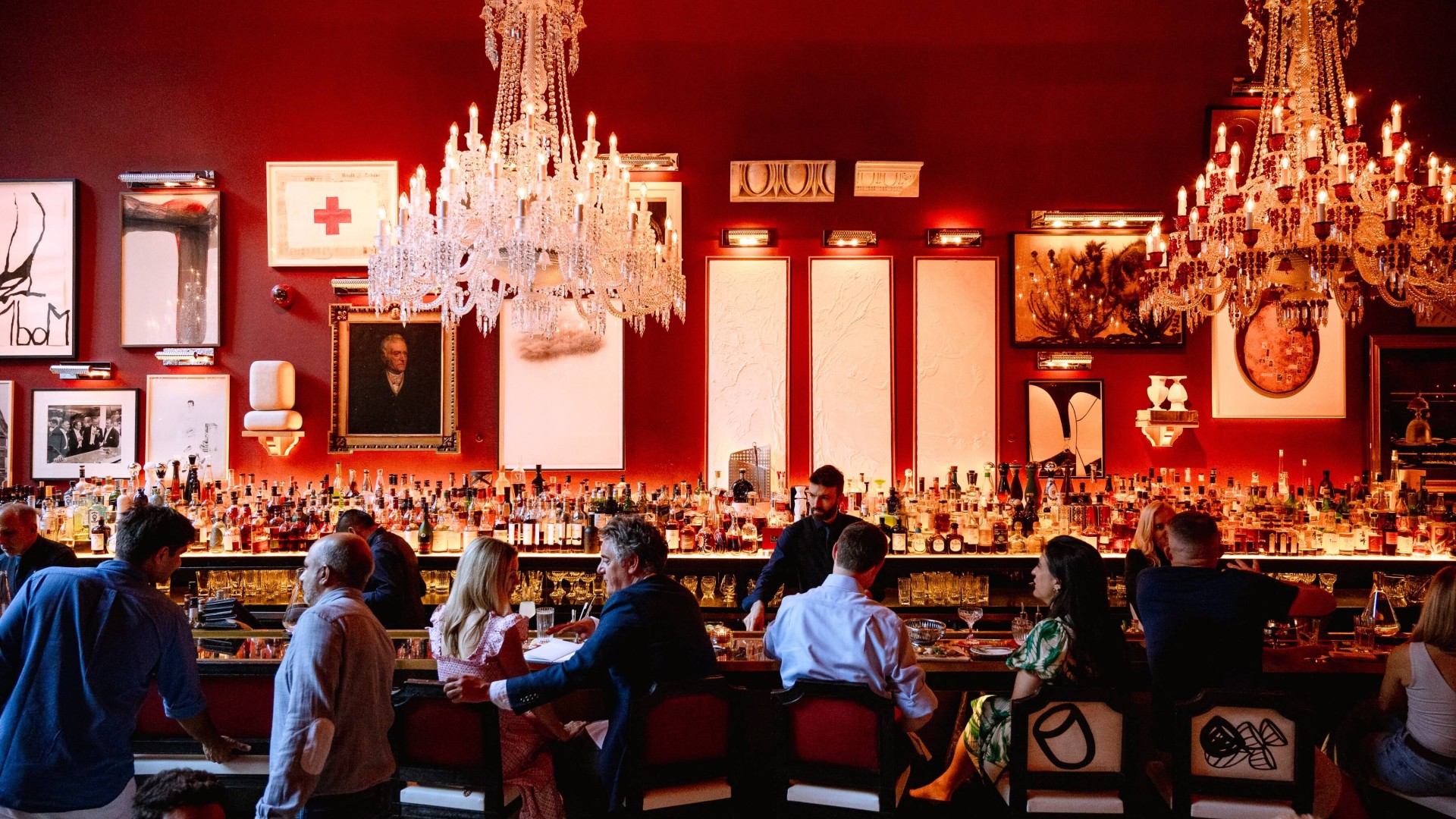 A vibrant red bar scene featuring patrons seated at tables, enjoying drinks and socializing