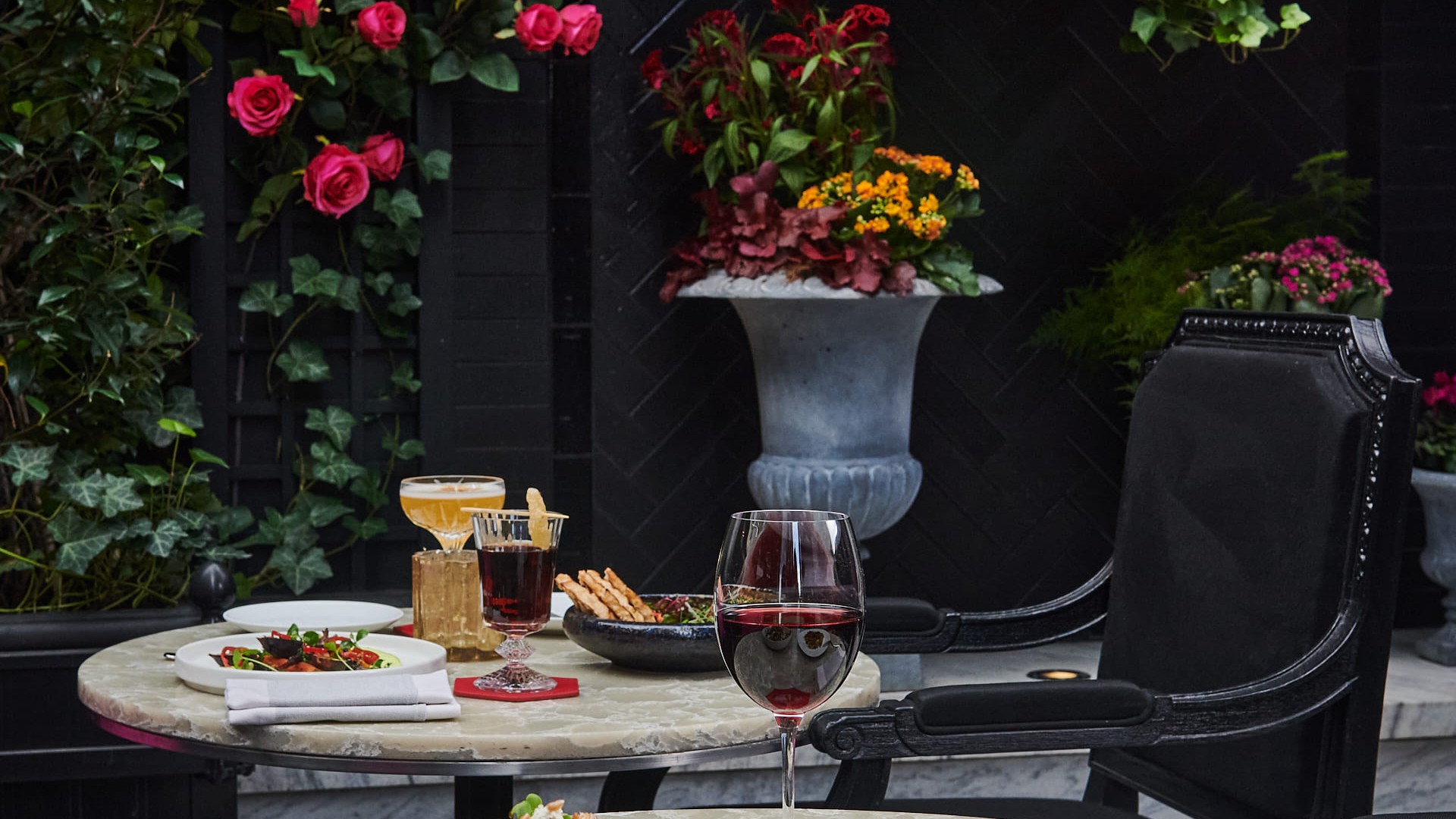 The patio decorated with beautiful flowers and gorgeous dishes on marble top tables