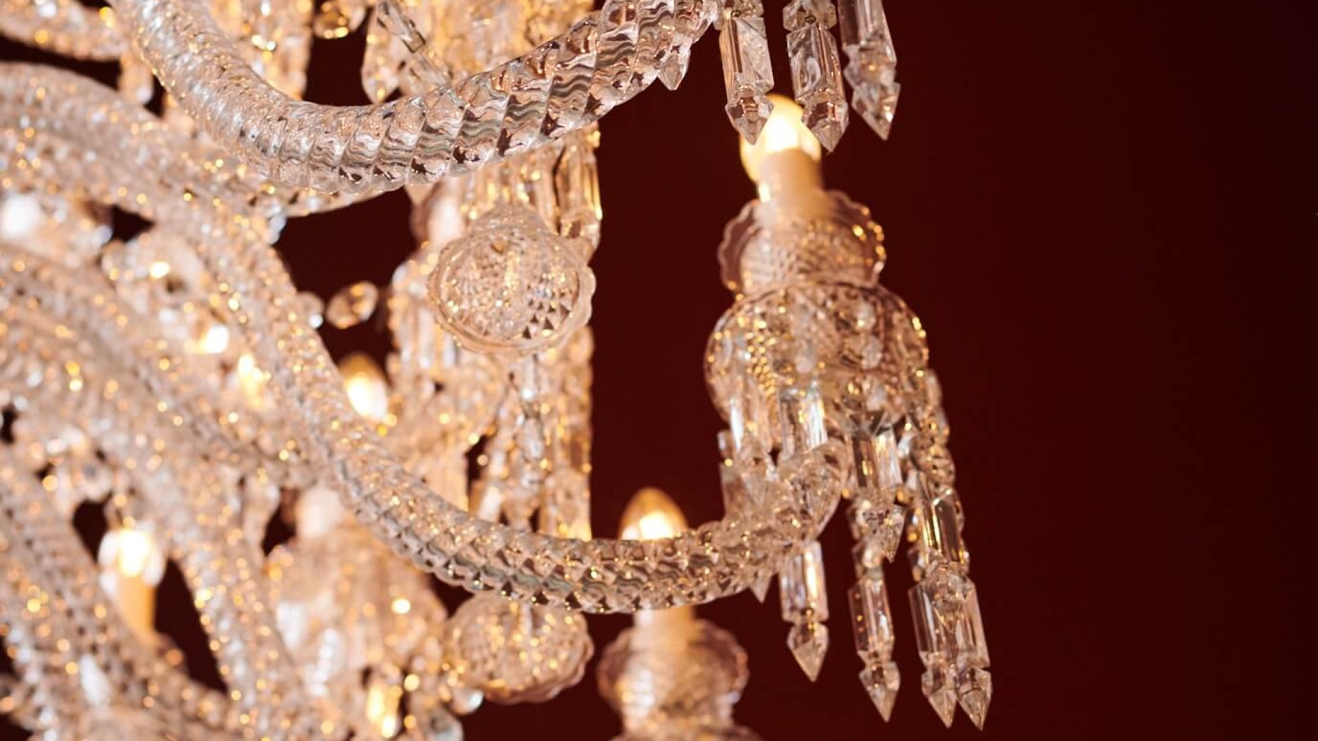 A crystal chandelier hangs elegantly from the ceiling, illuminating a beautifully decorated room below