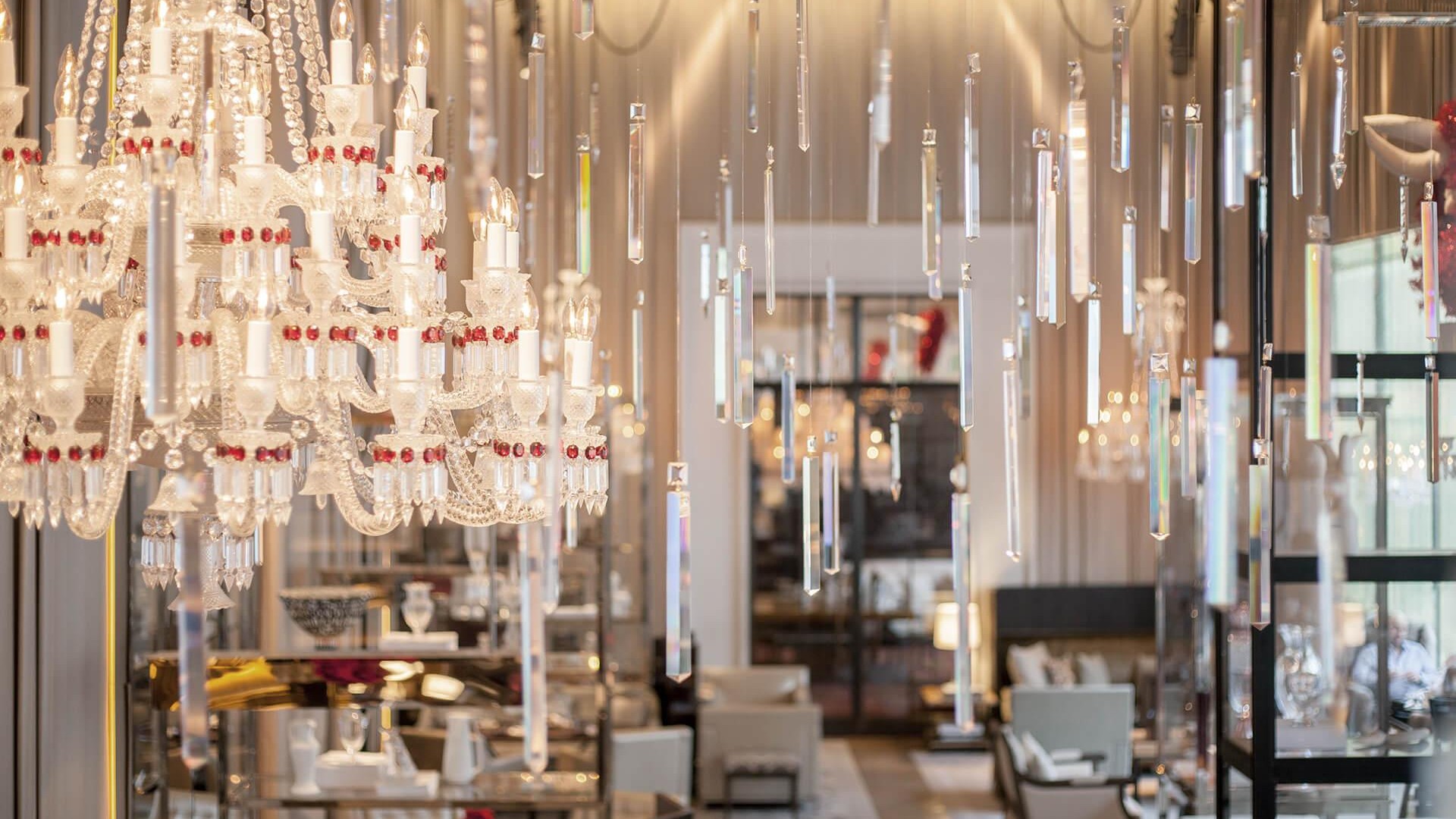  spacious room adorned with multiple chandeliers and elegantly arranged tables for an event or gathering.