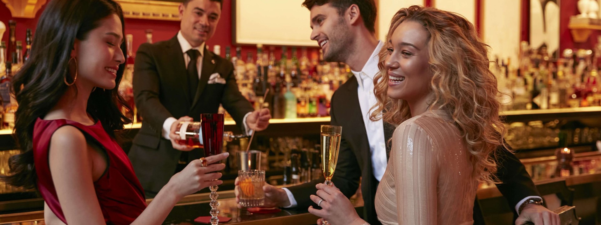Two women enjoying drinks together at a lively bar, chatting and laughing