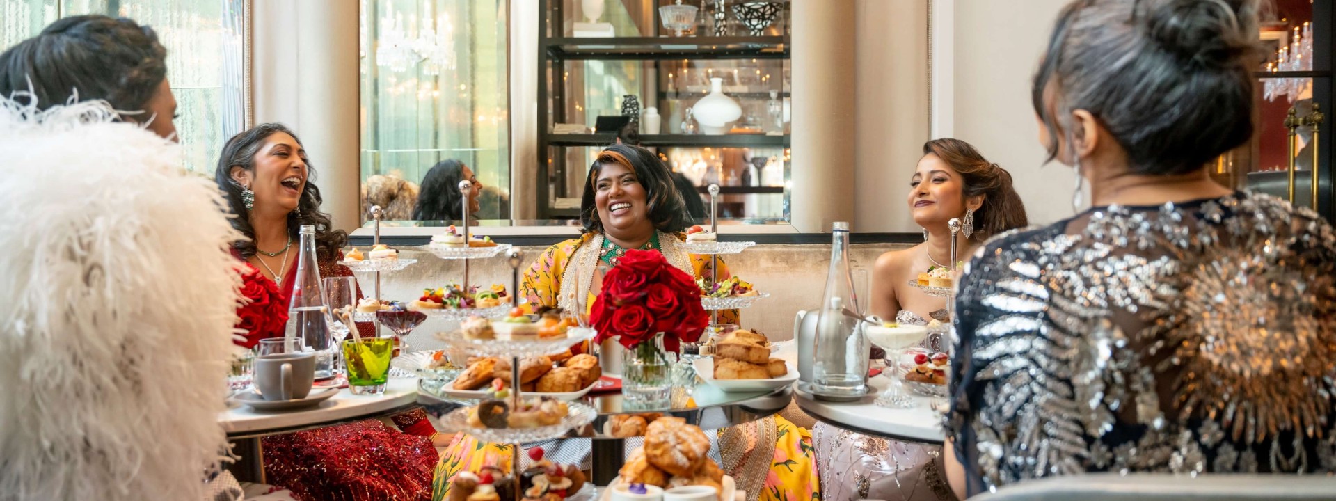 A group of women enjoying a meal together at an elegant restaurant, seated around a beautifully set table