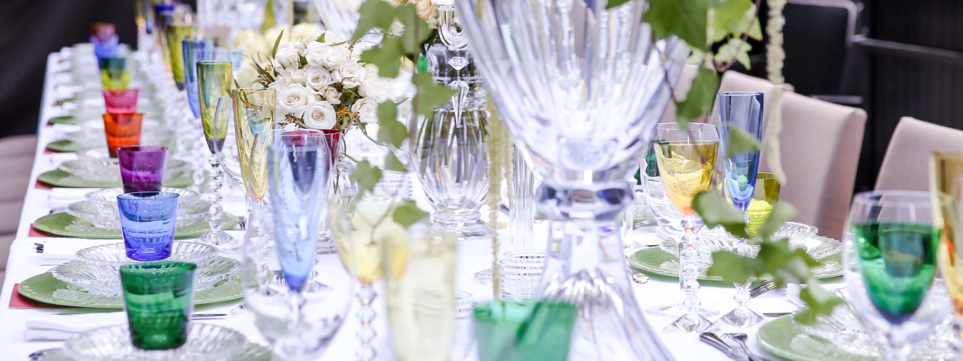 A beautifully arranged dinner table featuring colorful glasses and elegant tableware for a festive gathering