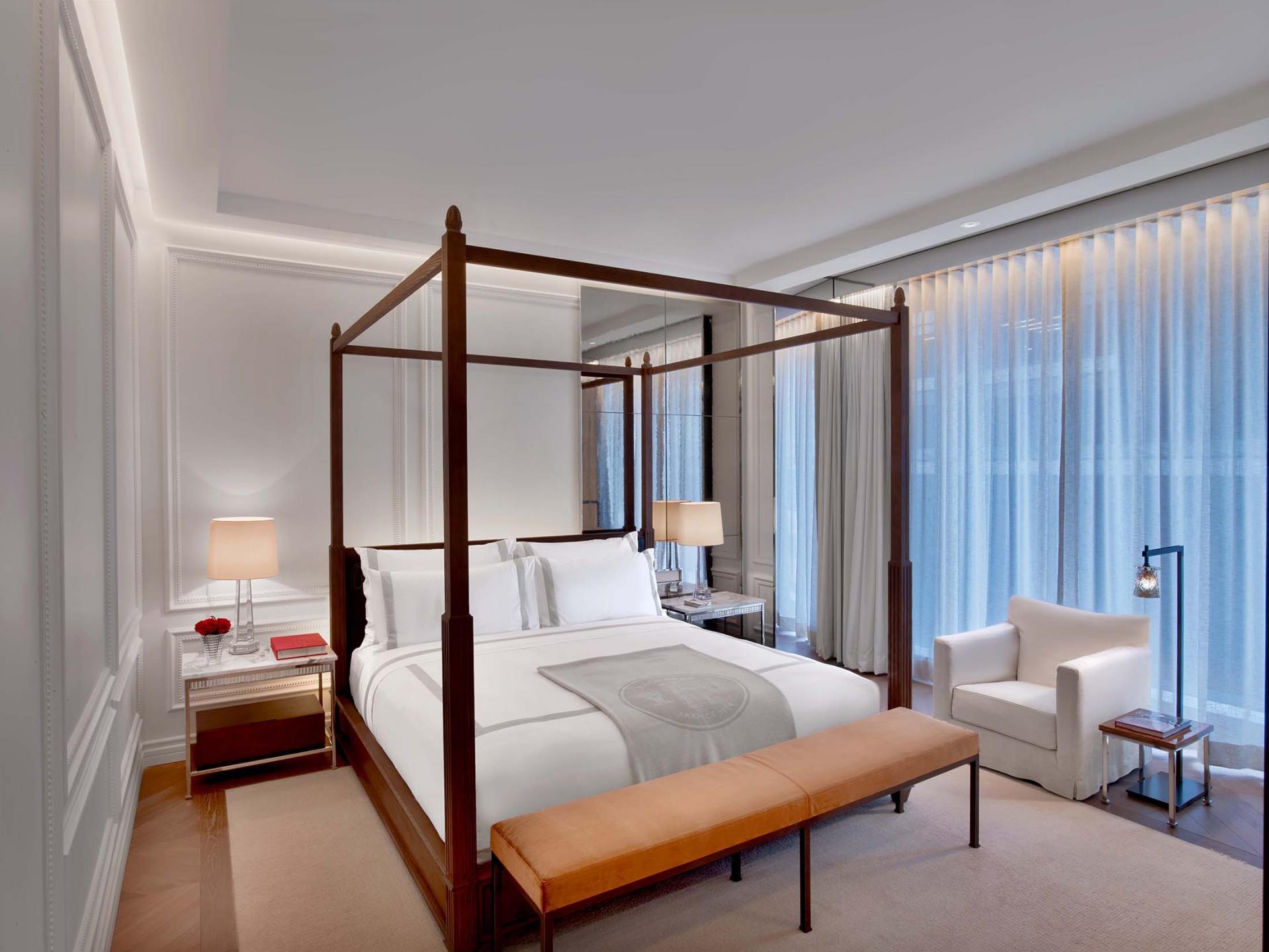 A four post king sized bed in a guest room at Baccarat hotel