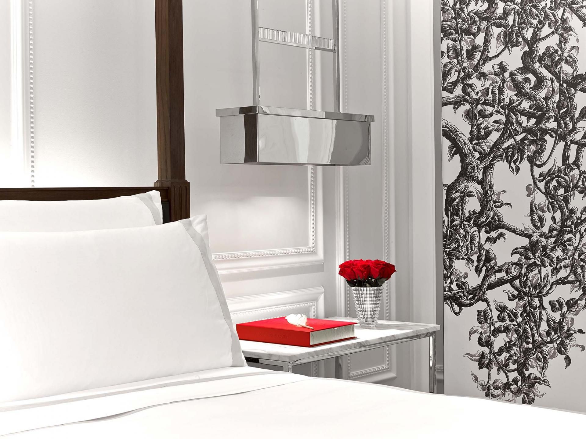 Baccarat hotel room bed side table with red roses
