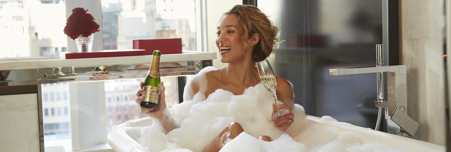 woman in bathtub drinking champagne
