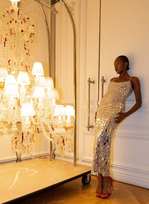 A woman posing next to a lamp