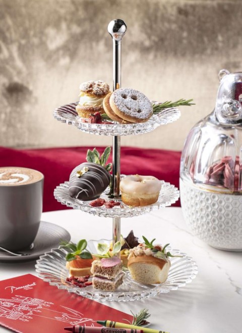 A tray featuring an assortment of pastries alongside a cup of coffee on a wooden table