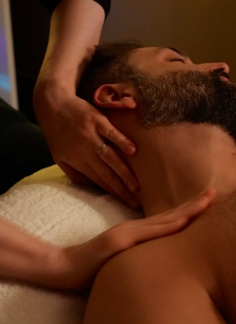 A man receiving a relaxing massage in a serene spa environment, surrounded by calming decor and soft lighting.