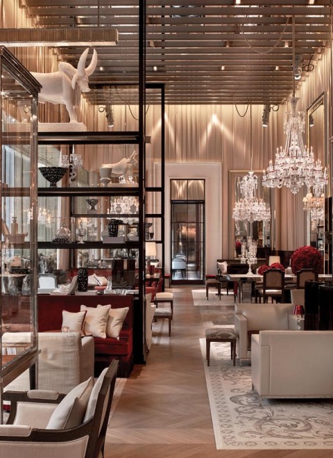 Elegant hotel lobby featuring ornate chandeliers and stylish tables, showcasing a luxurious atmosphere.