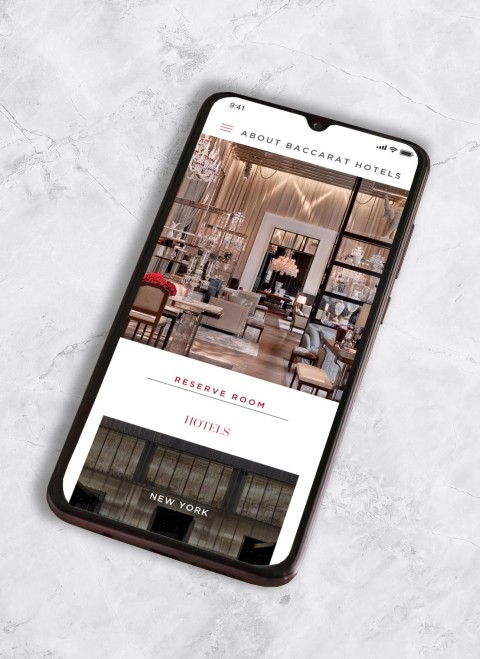 En un smartphone se muestra la página web de un restaurante, en la que aparecen los platos del menú y la información de contacto.