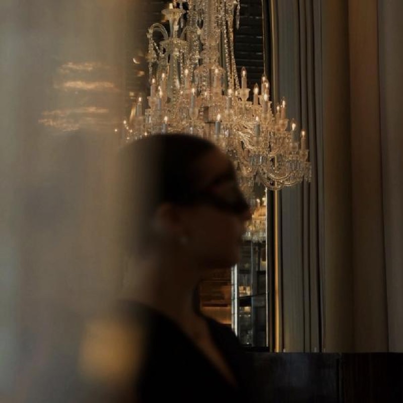 A woman standing in front of a chandelier 