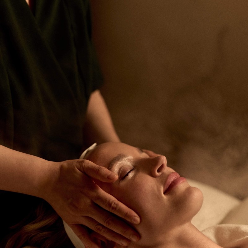 A woman enjoying a facial massage in a tranquil spa setting