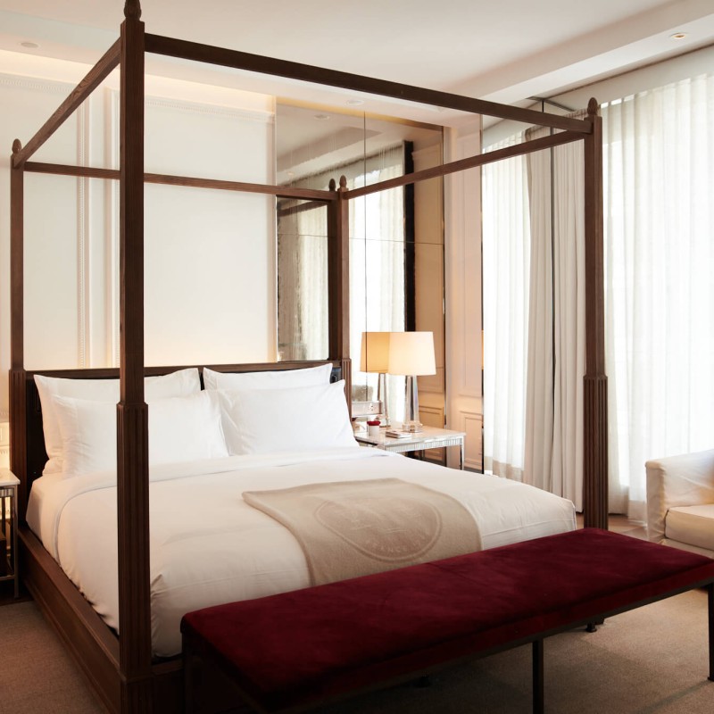 A cozy bedroom featuring a canopy bed and a window allowing natural light to enter the space.
