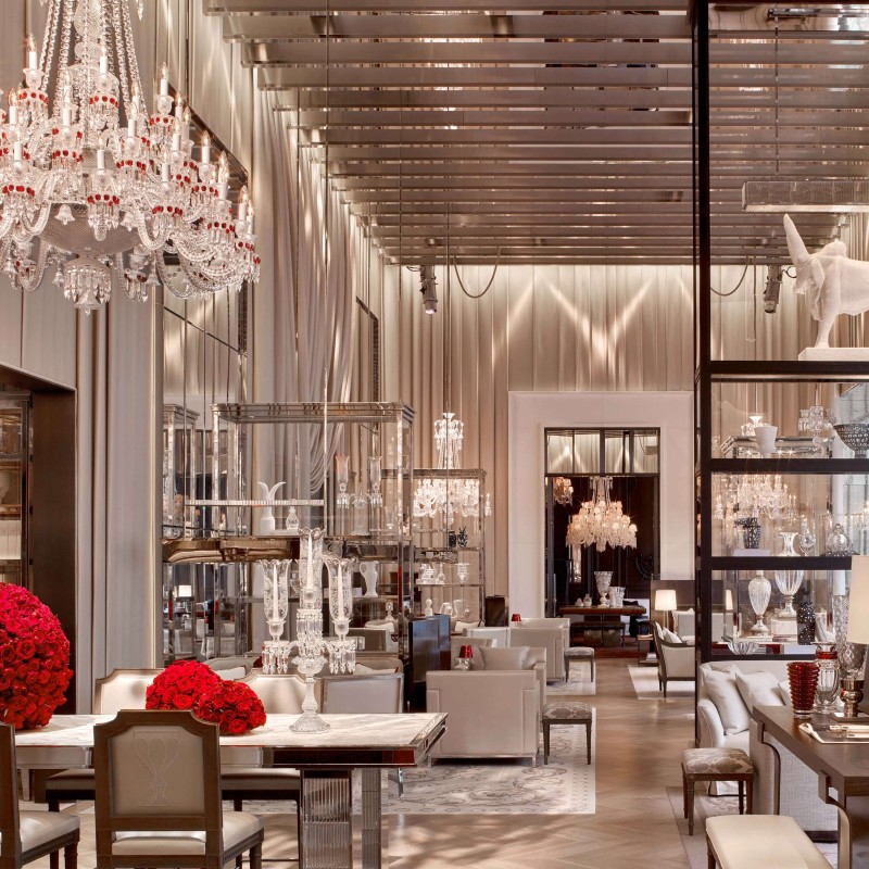 A spacious lobby featuring an elegant chandelier and various pieces of furniture arranged for comfort and style