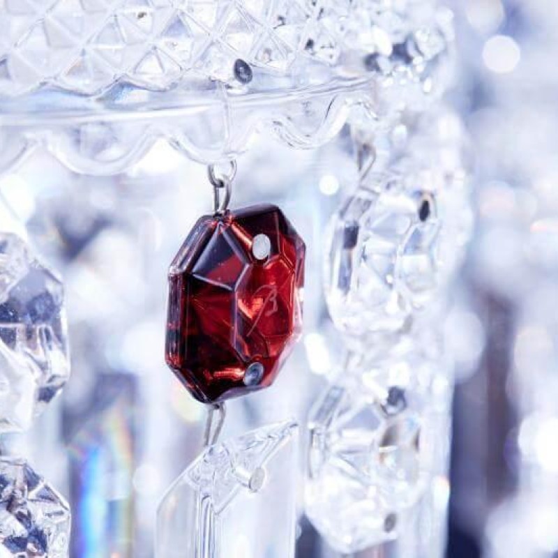 A red crystal chandelier adorned with a prominent red stone, showcasing intricate design and elegance.
