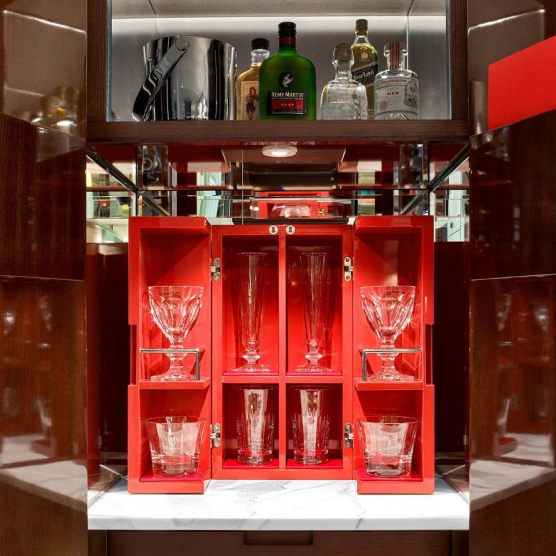 An organized cabinet featuring an array of wine bottles and glasses, highlighting a refined wine selection.