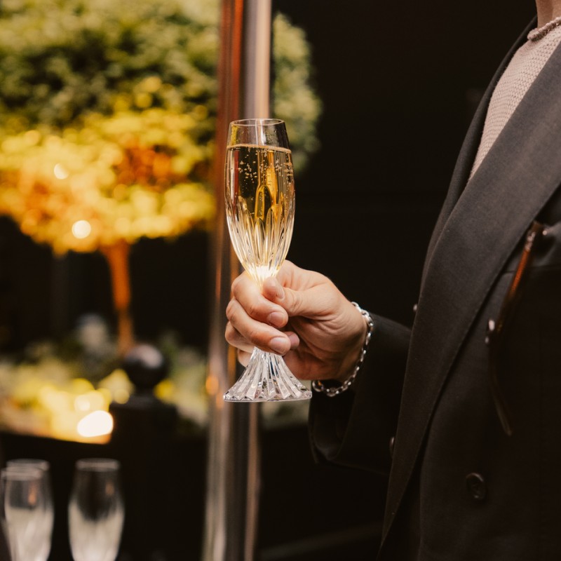 Uomo con un bicchiere di champagne in mano