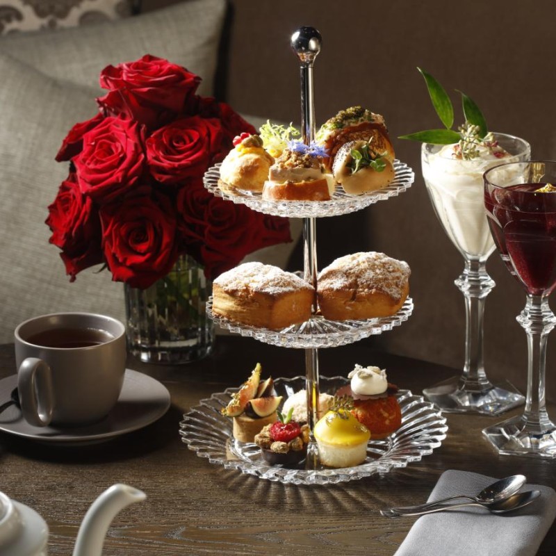 A beautifully arranged afternoon tea, showcasing delicate pastries and fine china in a luxurious setting.